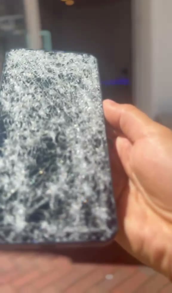 Samsung-Smartphone mit komplett zersplittertem Display in der Hand